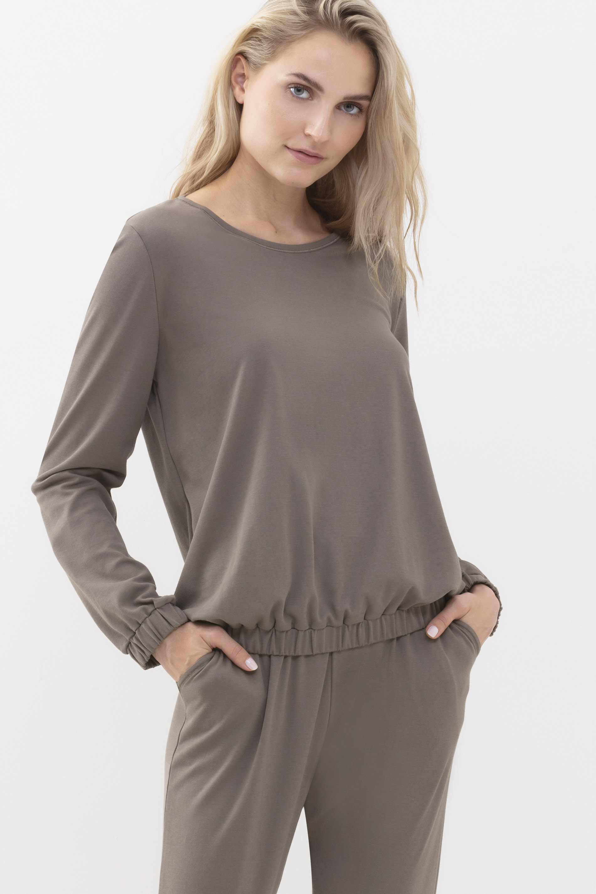 Blonde woman wears the long-sleeved top and long trousers in the color deep taupe from the series Zzzleepwear | mey® 