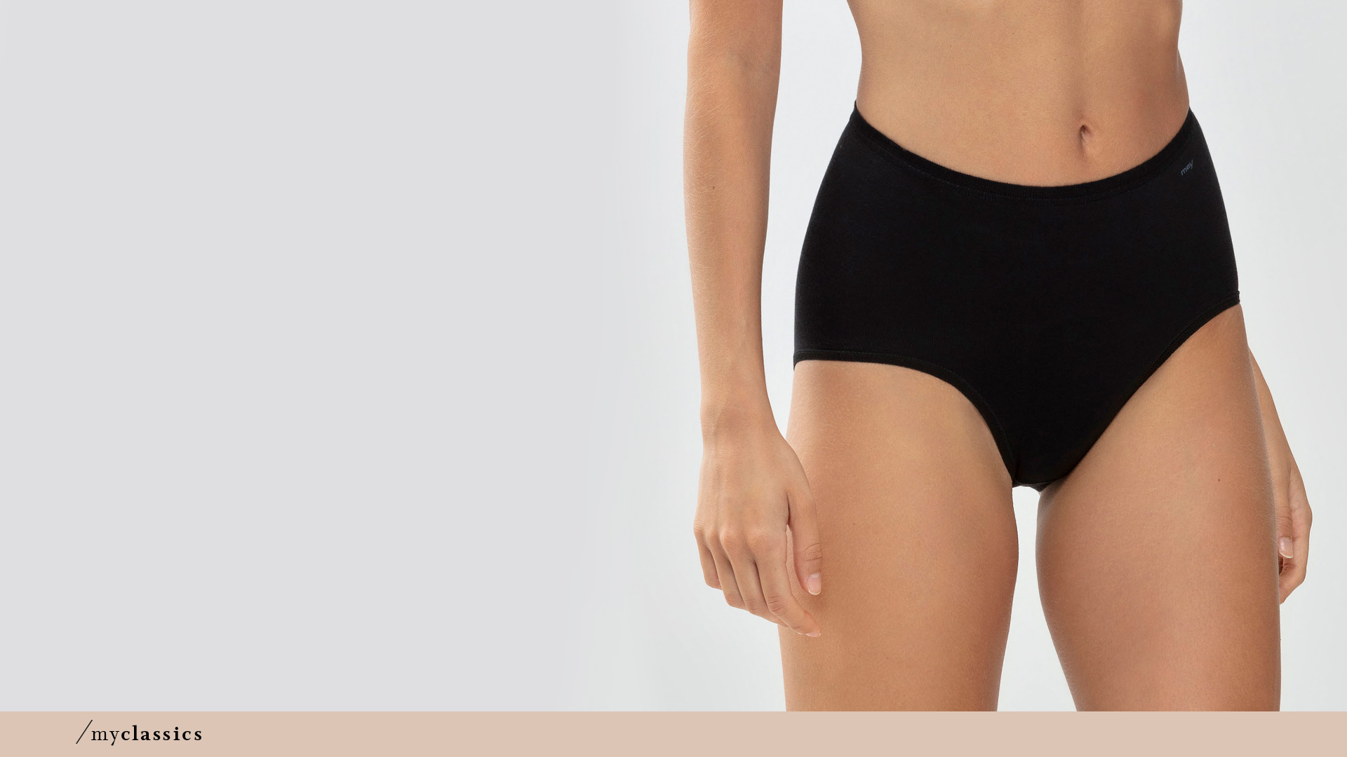 Woman wears black high-waisted briefs with shaping effect from the Only Lycra® series | mey®