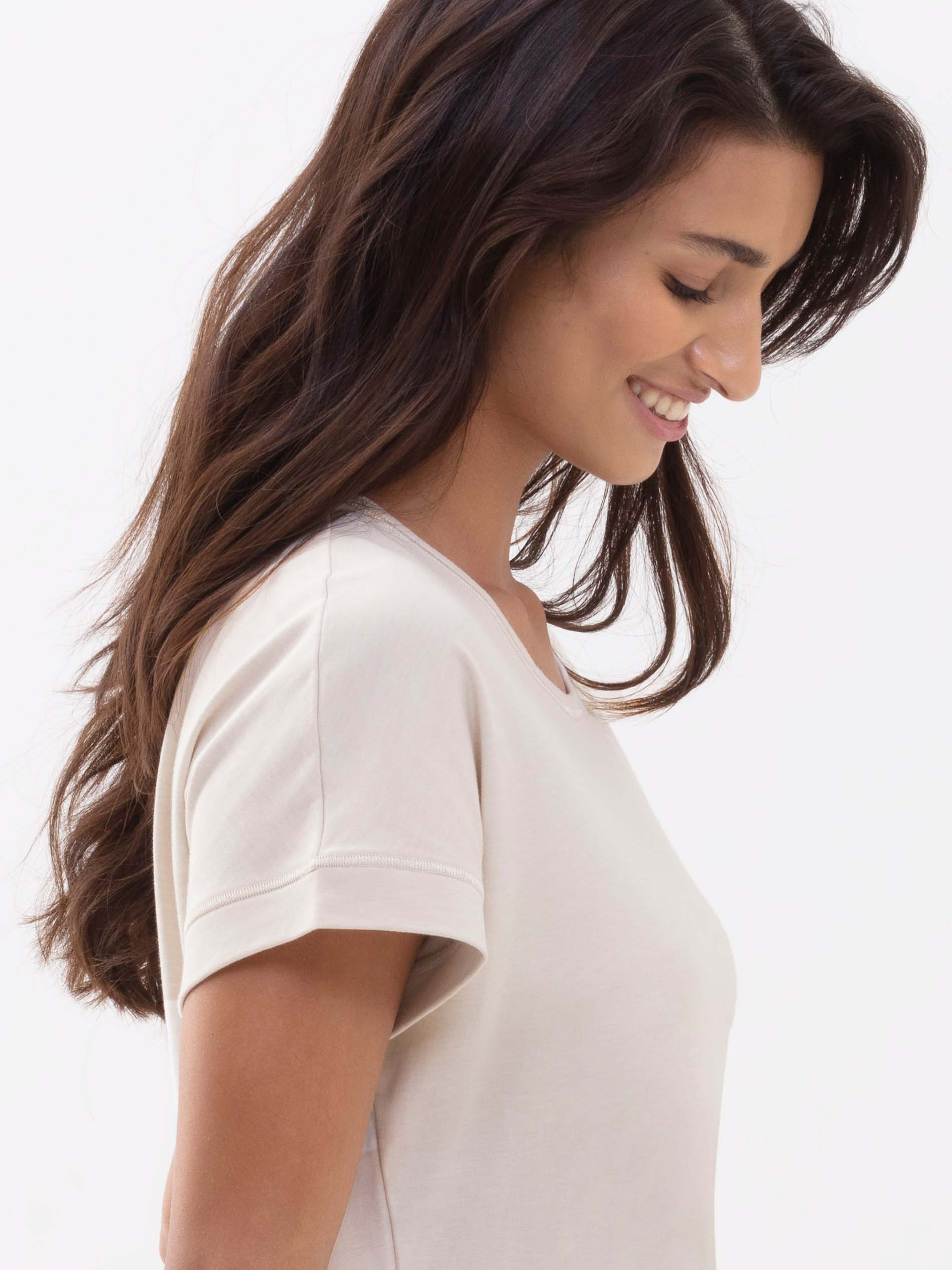 Seitenansicht des braunhaarigen Damenmodels, sie trägt das T-Shirt aus der Serie Zzzleepwear in der Farbe Natural | mey®