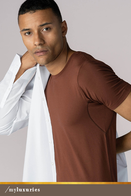 Mann trägt ein halb ausgezogenes, weißes Hemd sowie das Crew-Neck-Shirt in der Farbe Medium Skin aus der Serie Business Class | mey®