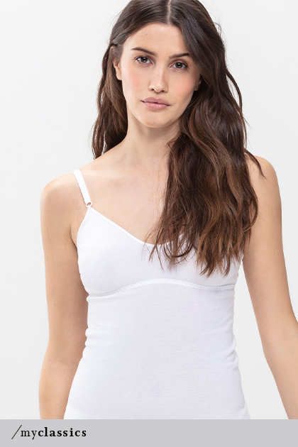Woman wears white bra top without side seams, made of Peruvian Pima cotton, from the Noblesse series | mey®