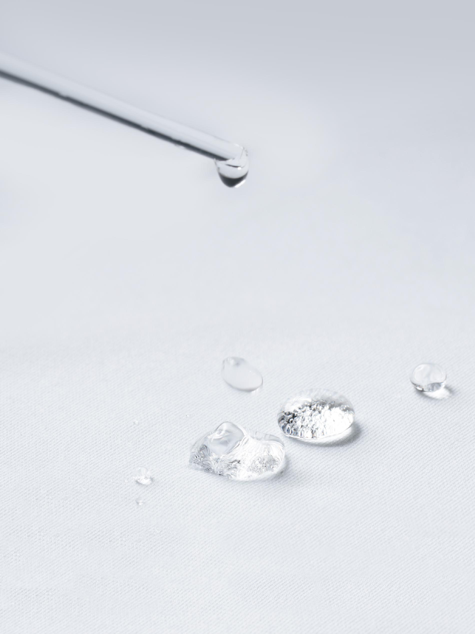 fabric layer with hydrophobic properties: water droplets are dripped onto white fabric from a pipette; they remain on the surface and are not absorbed by the fabric | mey®