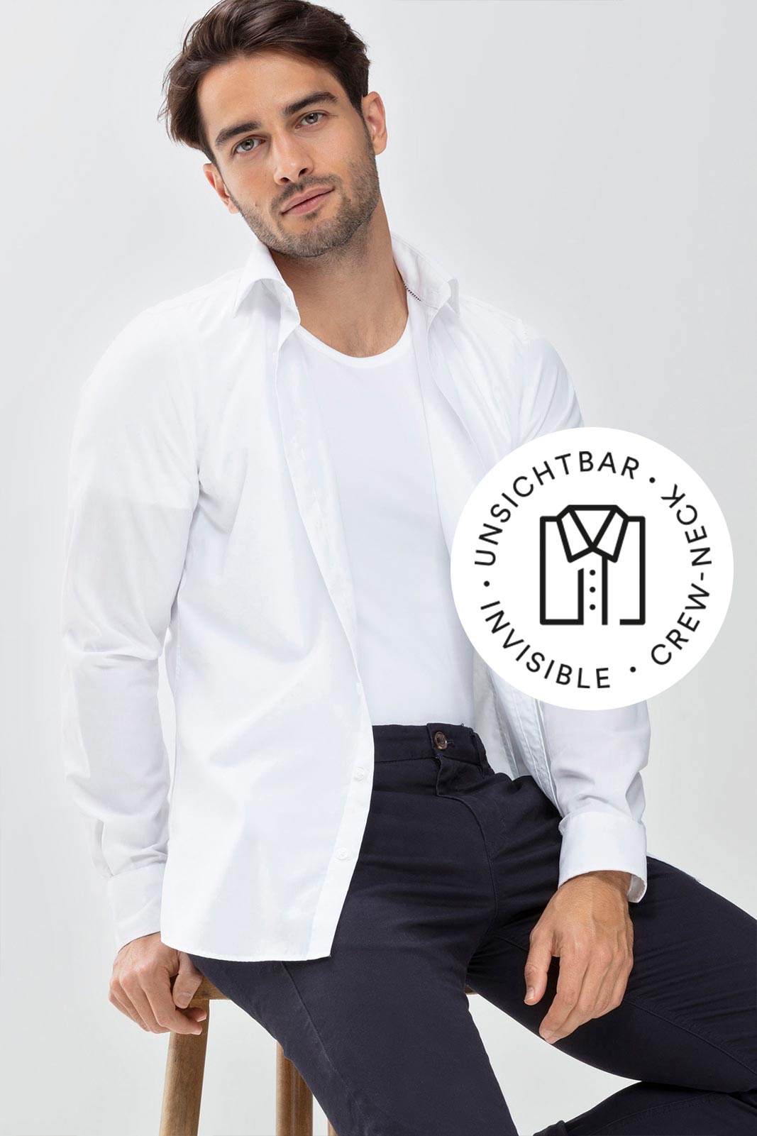 serie Dry Cotton Functional, model draagt wit crewneck-shirt met geopend wit hemd erover, mey®-symbool voor onzichtbaar crewneck-shirt: opgevouwen hemd met toegeknoopte kraag | mey®