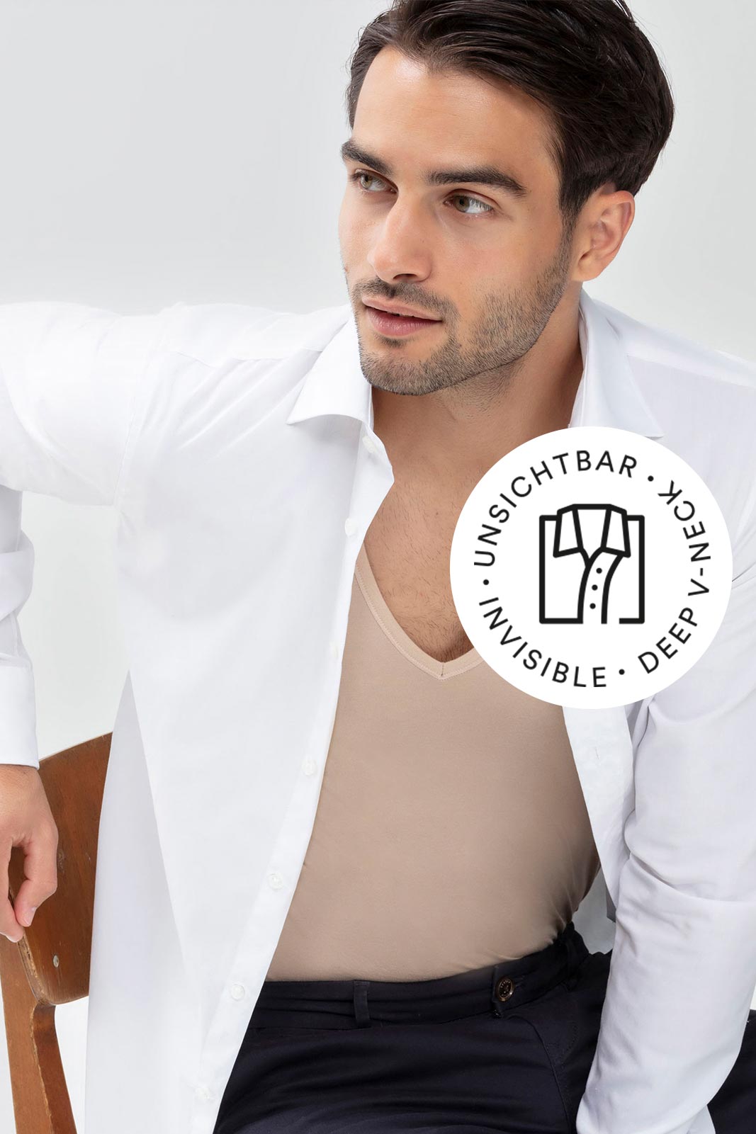 serie Dry Cotton Functional, model draagt shirt met V-hals in de kleur Light Skin met geopend wit hemd erover, mey®-symbool voor onzichtbaar shirt met V-hals: opgevouwen hemd met twee knopen en opengeknoopte kraag | mey®