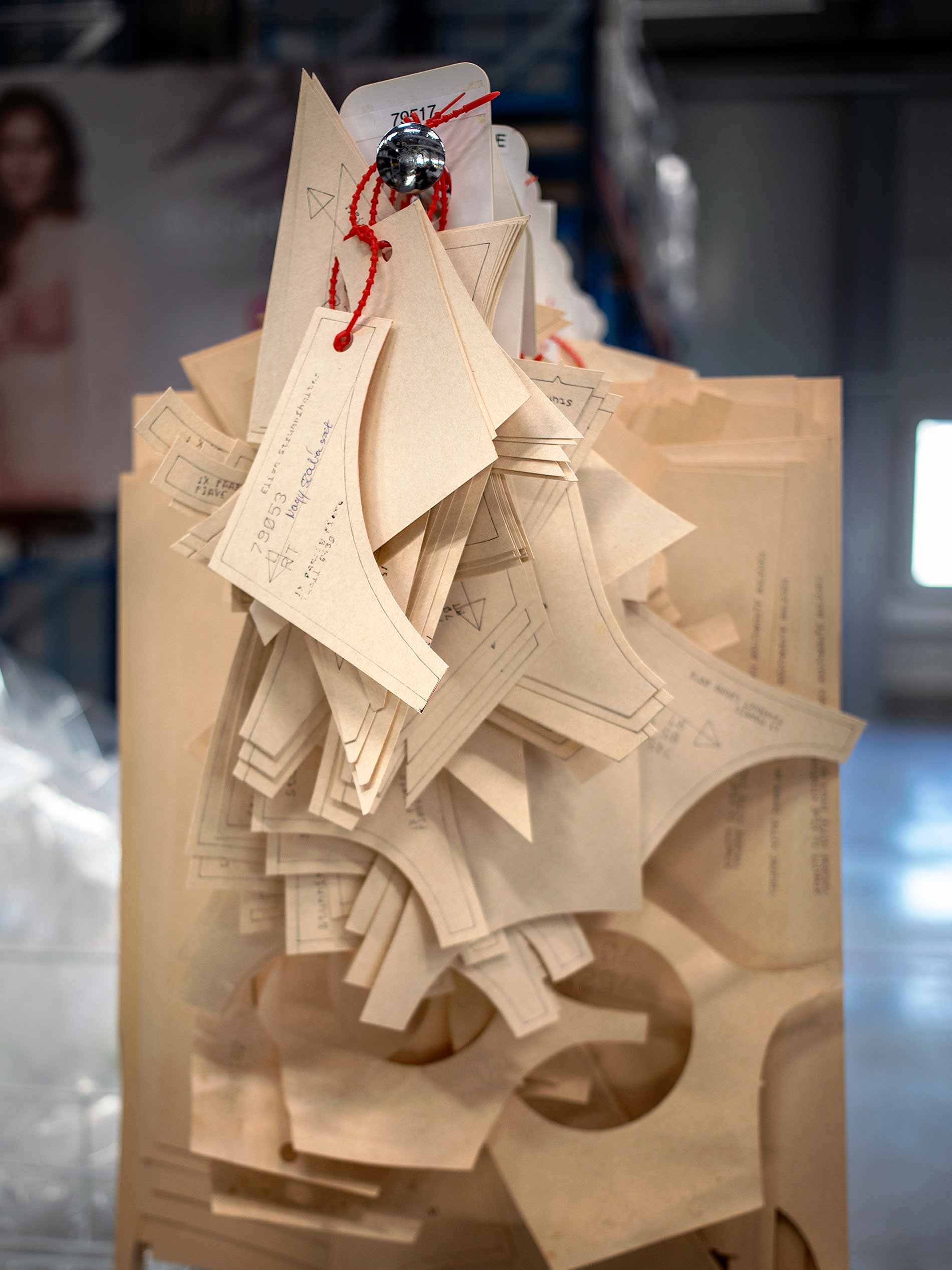 Zuschnitt-Vorlagen aus hellbraunem Karton hängen aufgereiht auf einer Kleiderstange | mey®