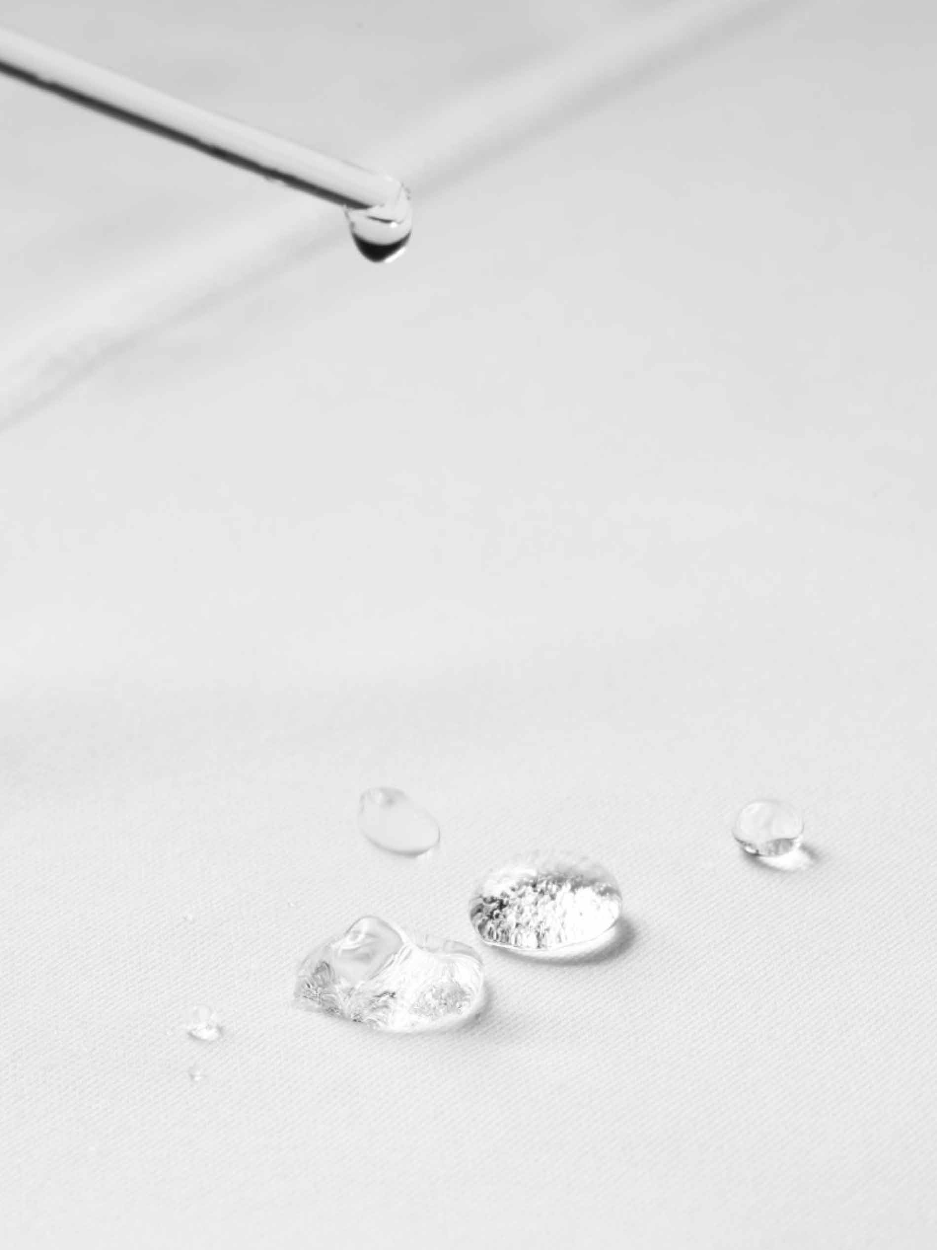 Water droplets collect on white fabric with hydrophobic properties | mey®
