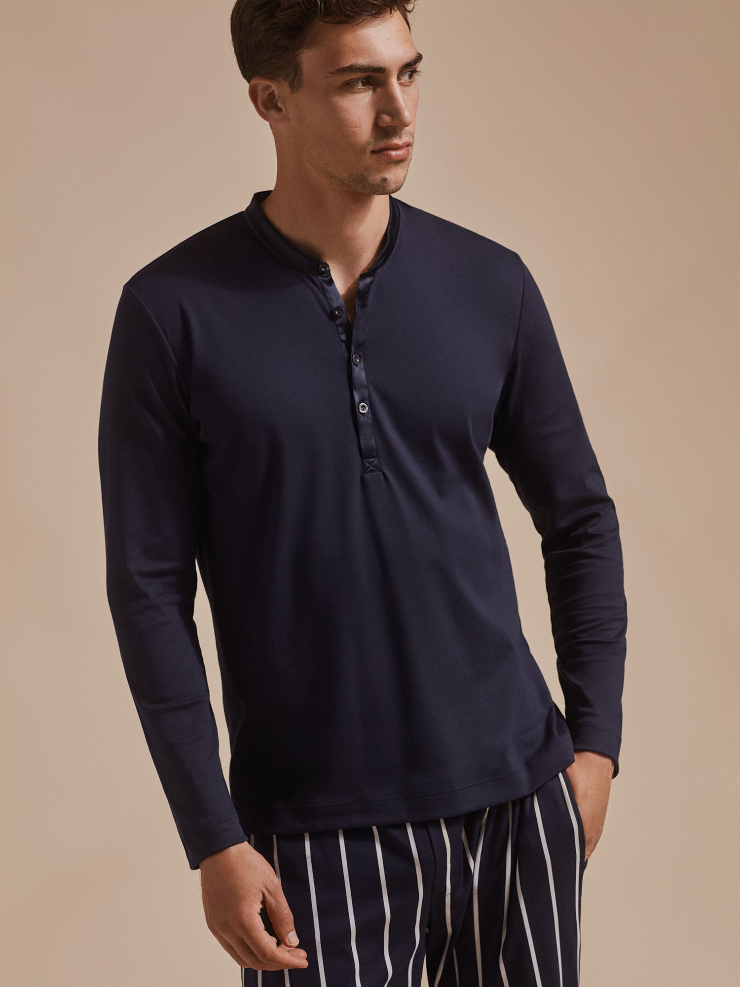 Männermodel steht in Henley-Langarm Pyjama-Shirt und gestreifter Hose | mey®